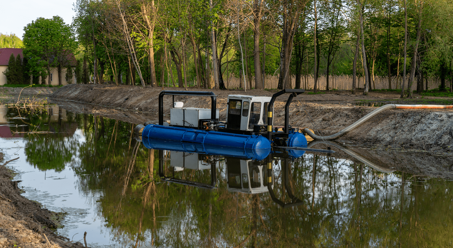 Small dredging boat on a calm river.